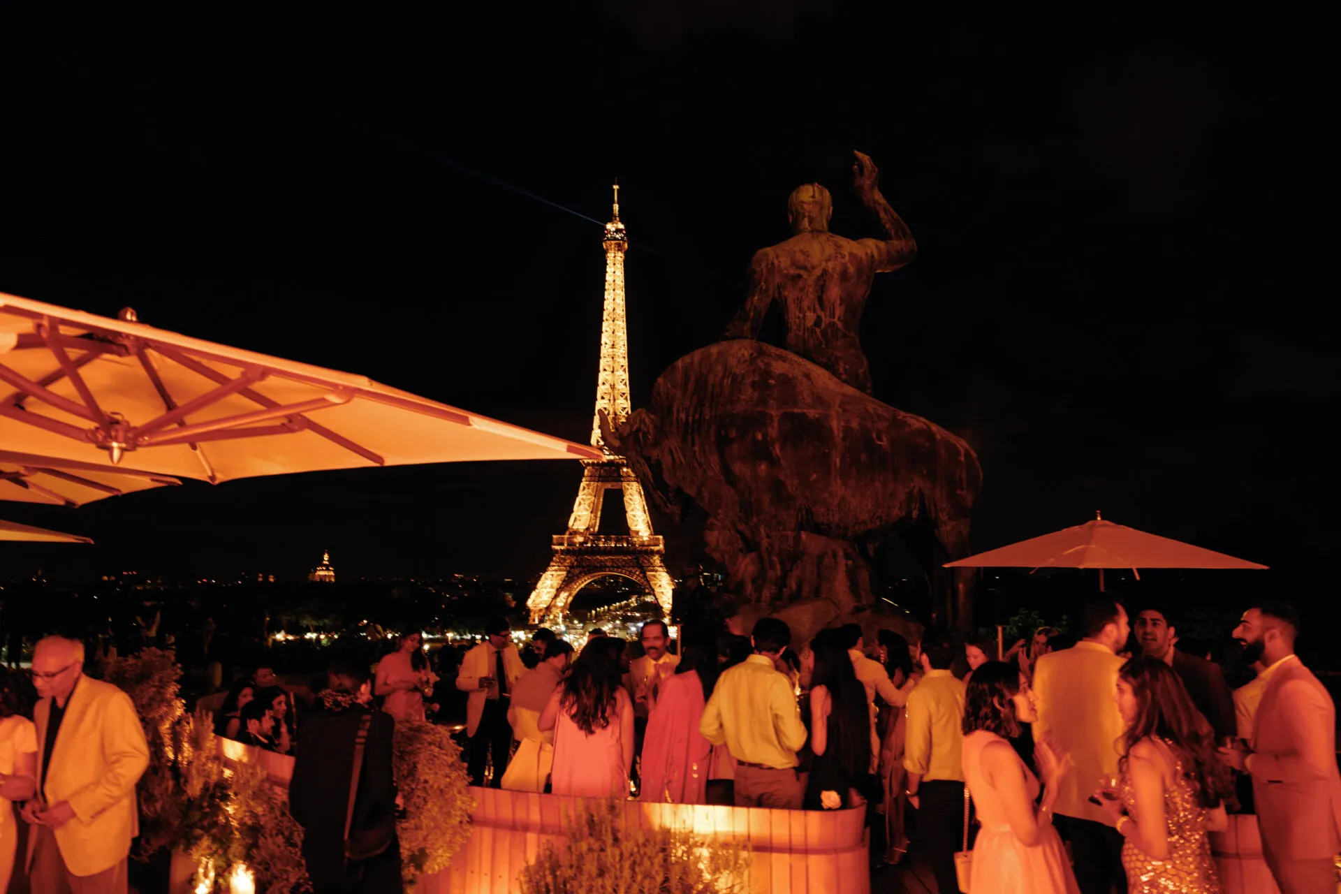Réception privée sur la terrasse à la nuit tombée, tour Eiffel illuminée