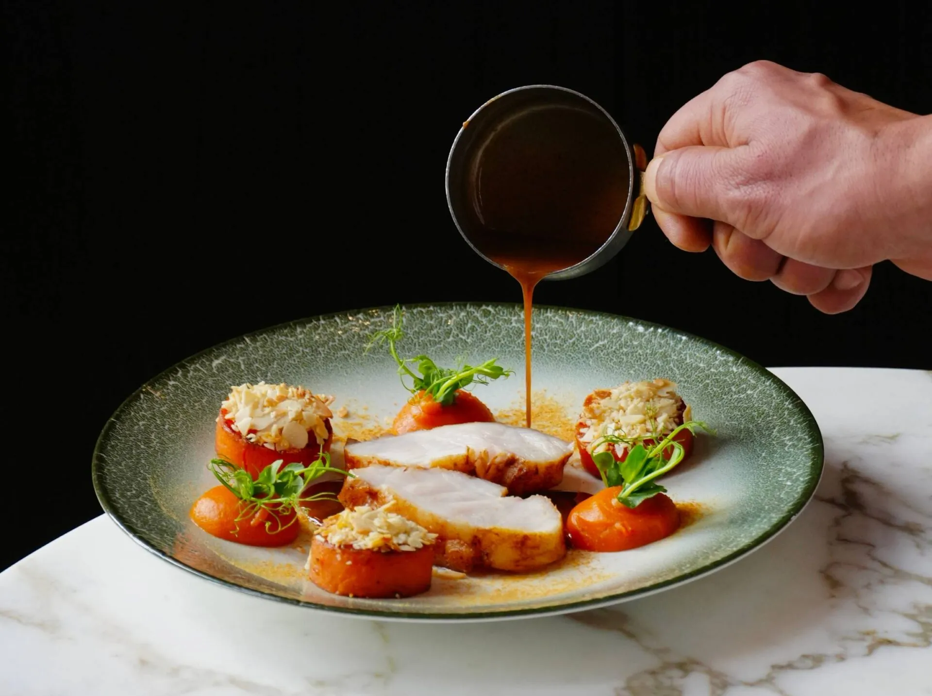 Assiette signature nappée de sauce au moment du service